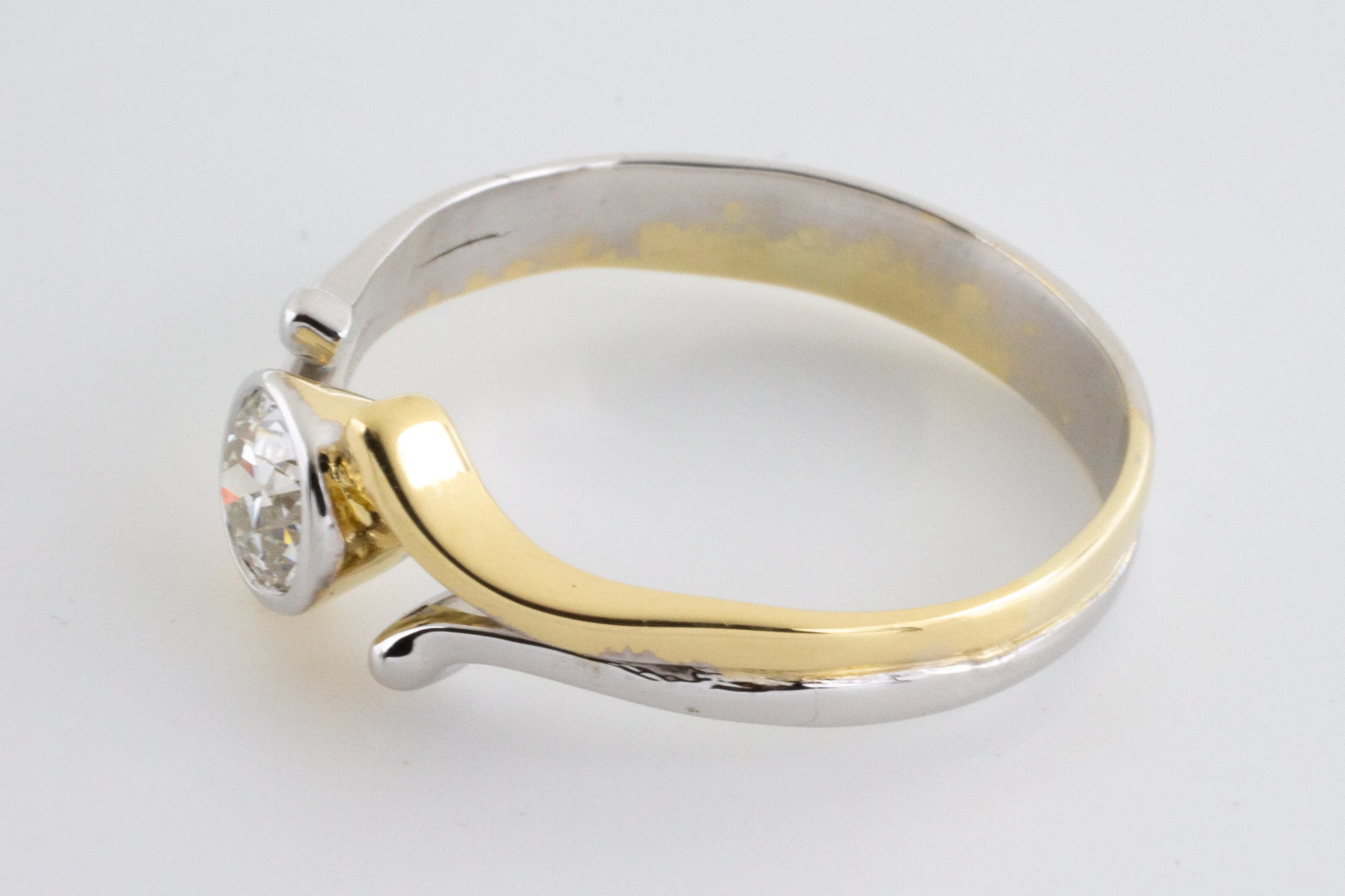 Old cut diamond solitaire ring in white and yellow gold.