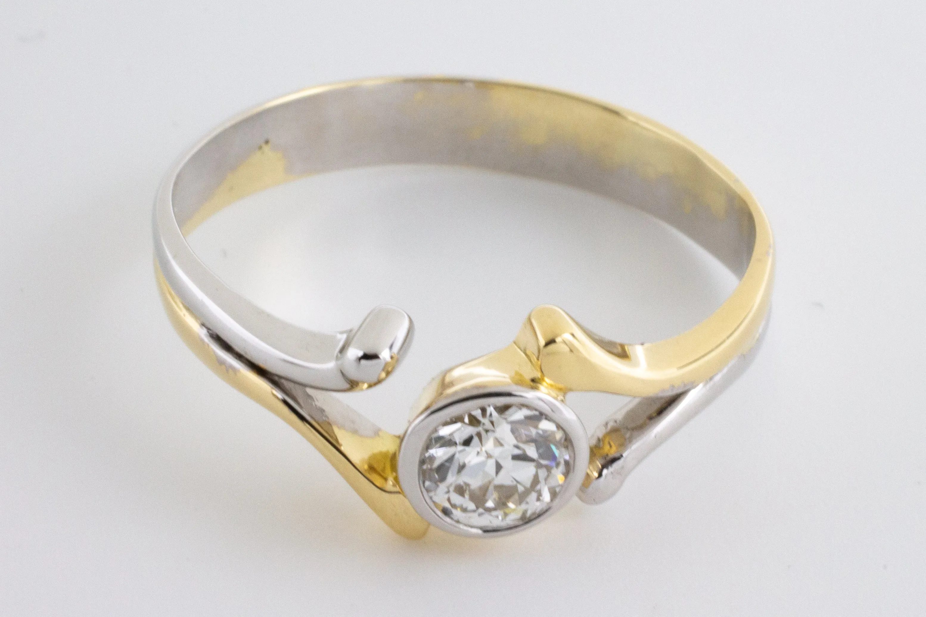 Old cut diamond solitaire ring in white and yellow gold.